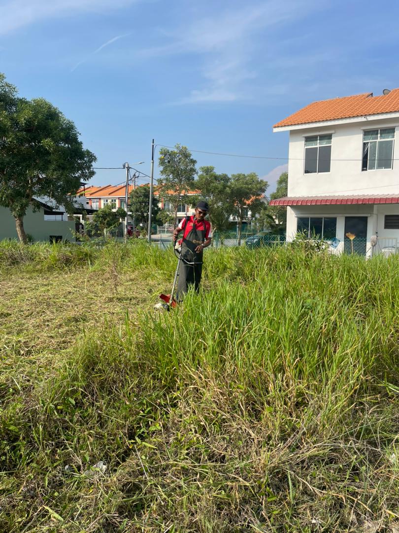 Kerja memotong rumput di kawasan tapak surau
